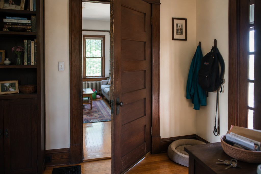 Entryway with wood door, built-in bookcase, coat hooks, and hardwood floors